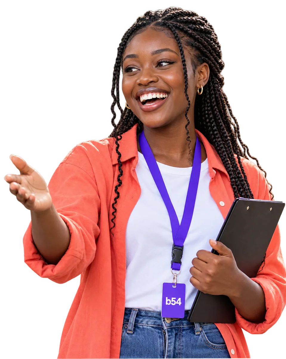 A laughing Campus Rep in a coral shirt and b54 lanyard directing arrivals while holding a clipboard